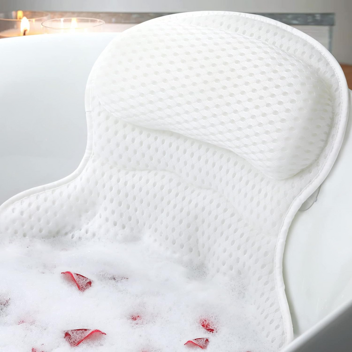 Ozyalo bath pillow for tub in white 4D mesh with ergonomic headrest and back support, shown in a relaxing bubble bath.